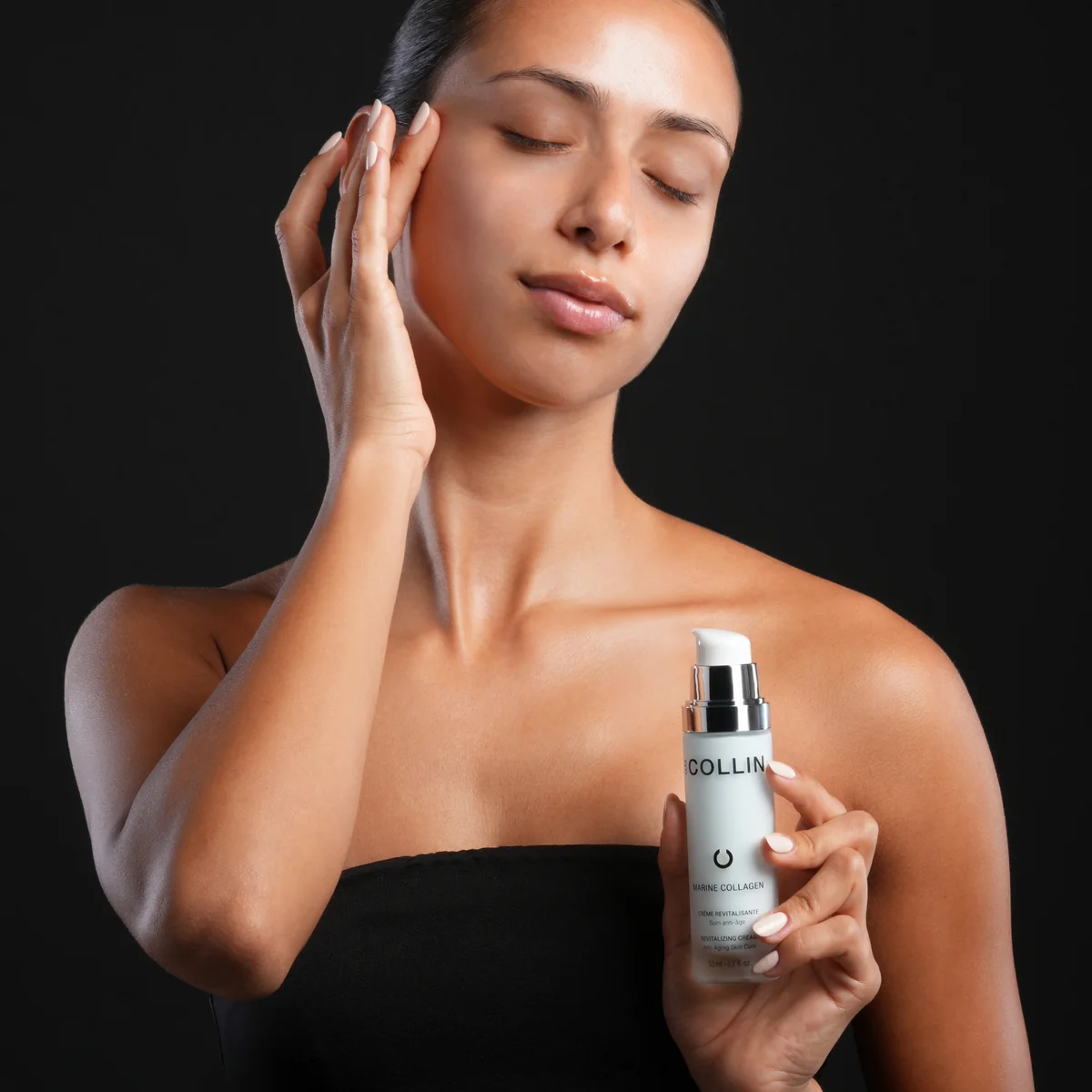 Marine Collagen Crème G.M. Collin - modèle tenant le flacon Marine Collagen fond noir élégant - Spa Santé Le Nénuphar