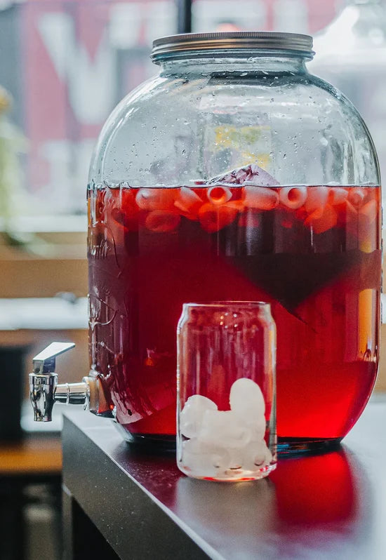 Grande bonbonne de boisson froide à la tisane Belle Framboise Urbanithé — rouge vif avec glaçons, style bistro