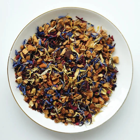Mélange de tisane Belle Framboise Urbanithé — fleurs de bleuet, morceaux de fruits séchés et pétales colorés dans un bol blanc
