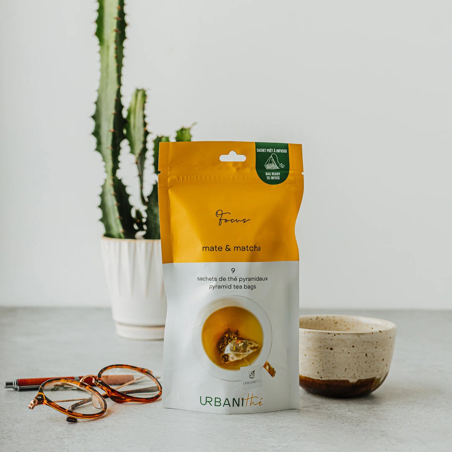 Emballage vert Cold Infusions À Froid Focus Urbanithé 25 sachets sur table en bois avec verre glacé et livre ouvert