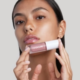 Femme appliquant l’huile à lèvres repulpante sur ses lèvres pour un effet hydratant et repulpant