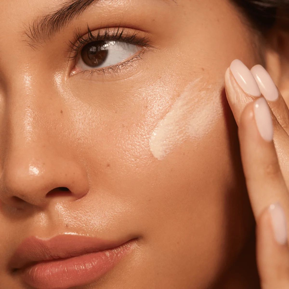 Application de l'écran solaire minéral SolarGlow NUDA sur le visage — texture légère sans traces blanches — Spa Santé Le Nénuphar