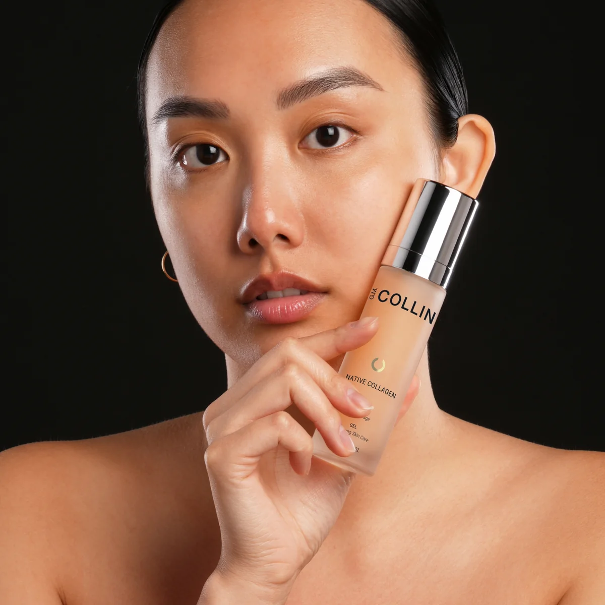 Native Collagen Gel G.M. Collin - modèle tenant le flacon Native Collagen fond noir élégant peau lumineuse - Spa Santé Le Nénuphar