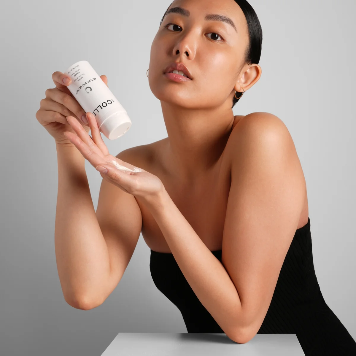 Active Exfoliant Poudre G.M. Collin - modèle tenant le pot exfoliant poudre Active - Spa Santé Le Nénuphar