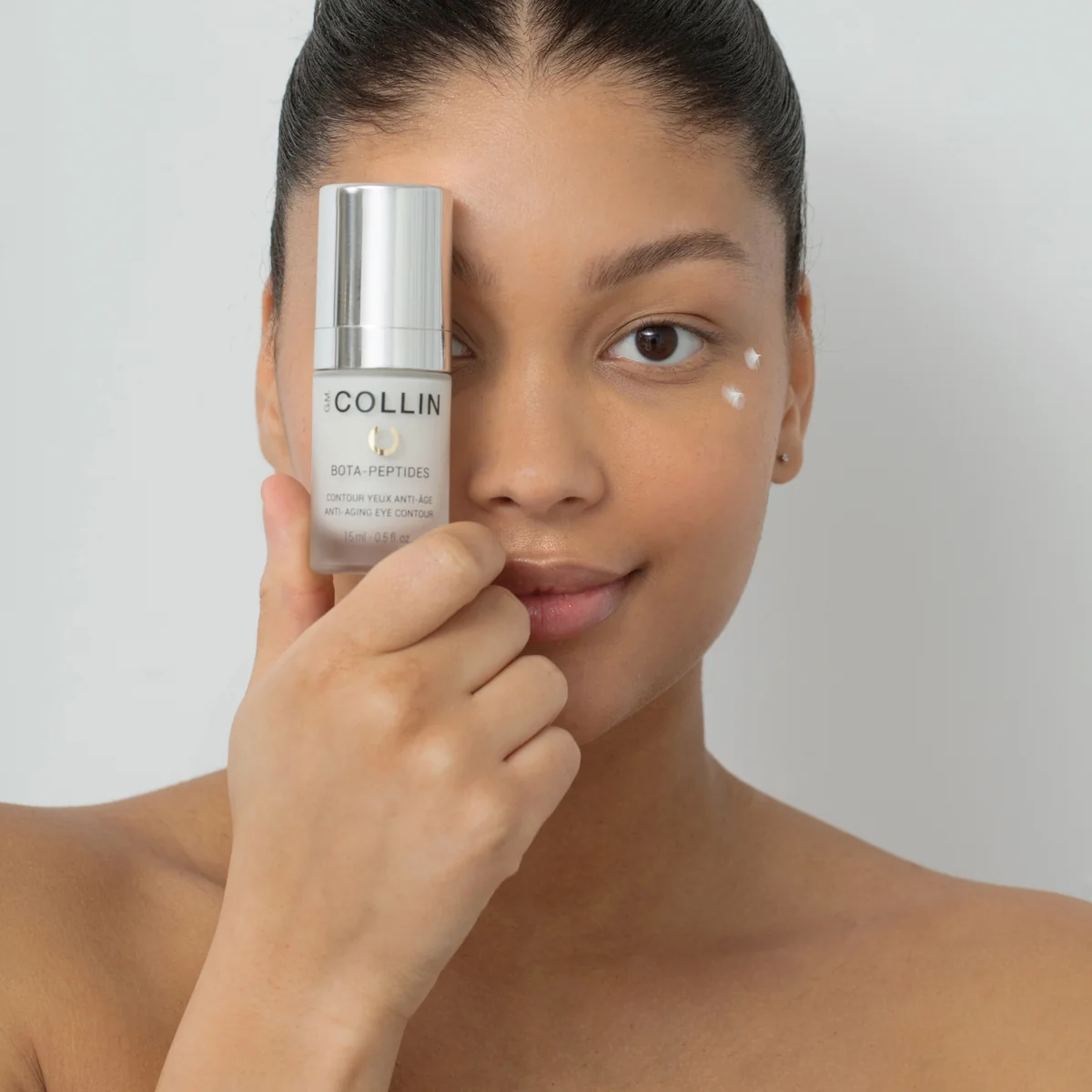 Bota-Peptides Contour des yeux G.M. Collin - modèle tenant le flacon devant l’œil avec application contour - Spa Santé Le Nénuphar