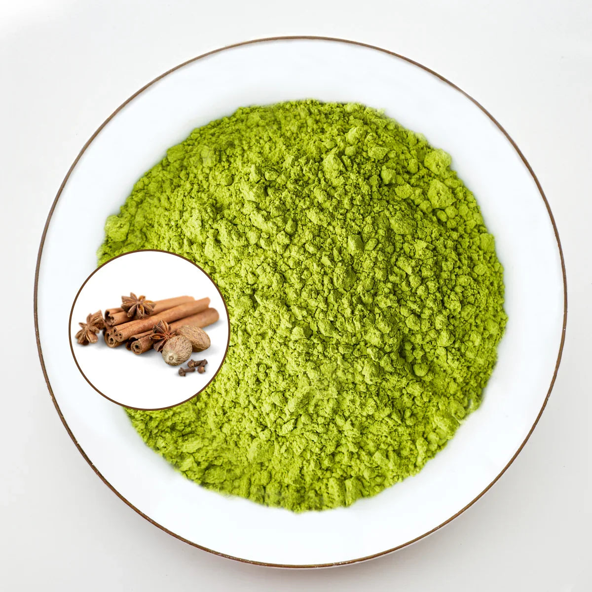 Vue de dessus poudre de matcha vert vif Urbanithé saveur chai dans assiette blanche bordée or avec médaillon cannelle, anis étoilé, muscade et clous de girofle, fond blanc