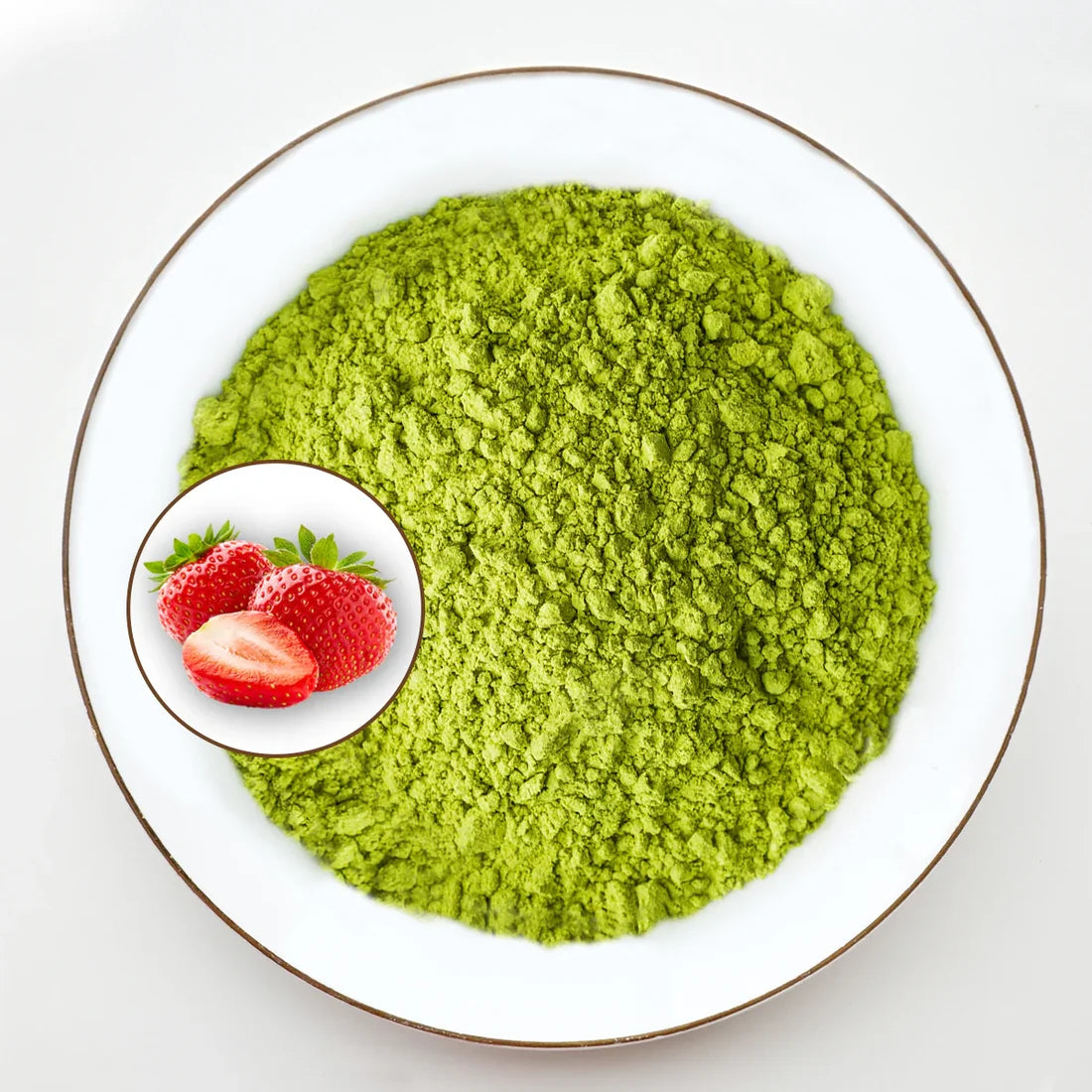 Vue de dessus poudre de matcha vert vif Urbanithé saveur fraise dans assiette blanche bordée or avec médaillon fraises rouges fraîches, fond blanc
