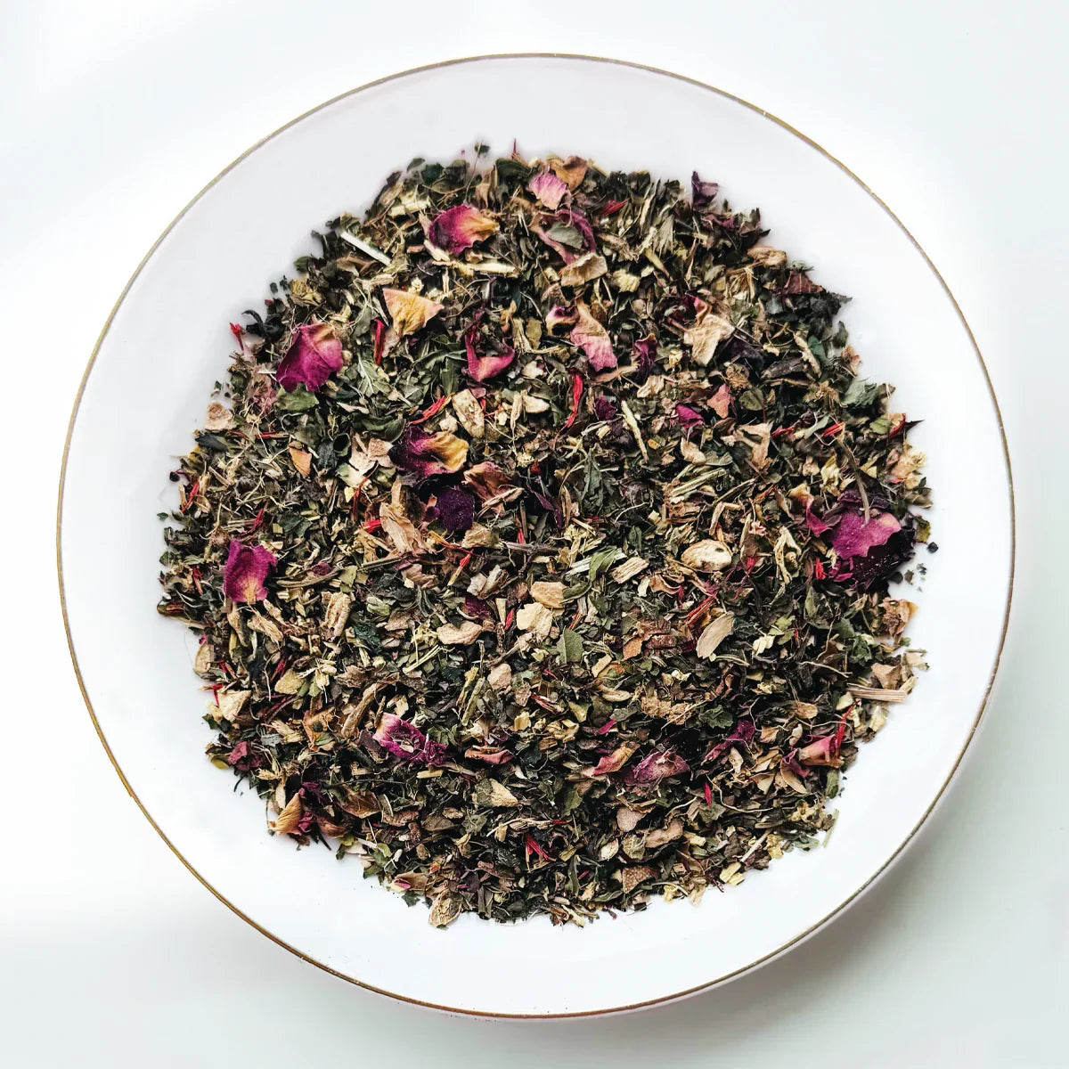 Mélange de tisane Detox Urbanithé dans un bol blanc — feuilles séchées, pétales de rose et herbes dépuratives
